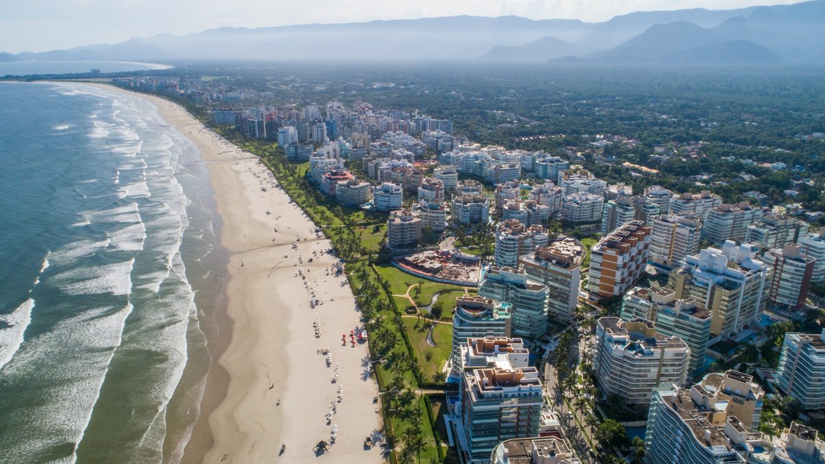 Morar em Bertioga: vista aérea da orla verticalizada da Riviera de São Lourenço com a Serra do Mar ao fundo